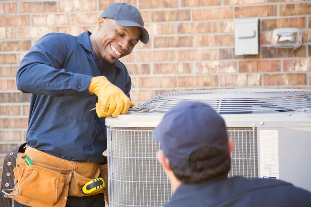 hvac tech working on ac unit